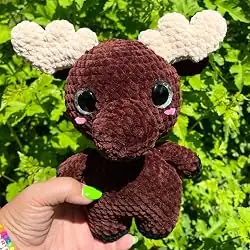 Handmade crochet moose held up outdoors